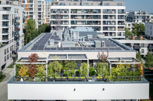 Ukwiecony balkon na ostatnim piętrze nowoczesnego budynku.