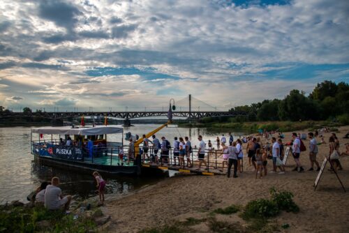 Ludzie wchodzą na prom na Wiśle