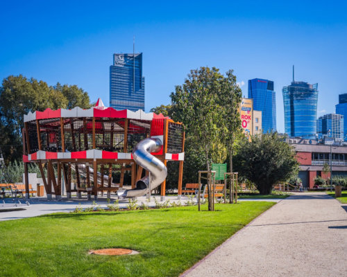 Skwer Gwary Warszawskiej - alejka, trawnik, urządzenie do zabaw w kształcie karuzeli