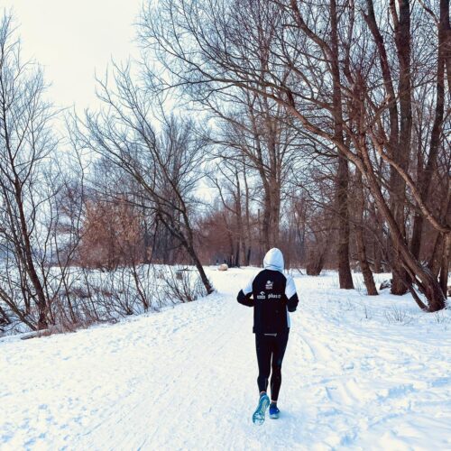 Mężczyzna biegnie wzdłuż Wisły wśród drzew