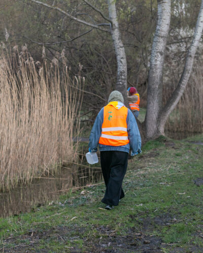 dwie wolontariuszki idą wzdłuż rowu przy ulicy