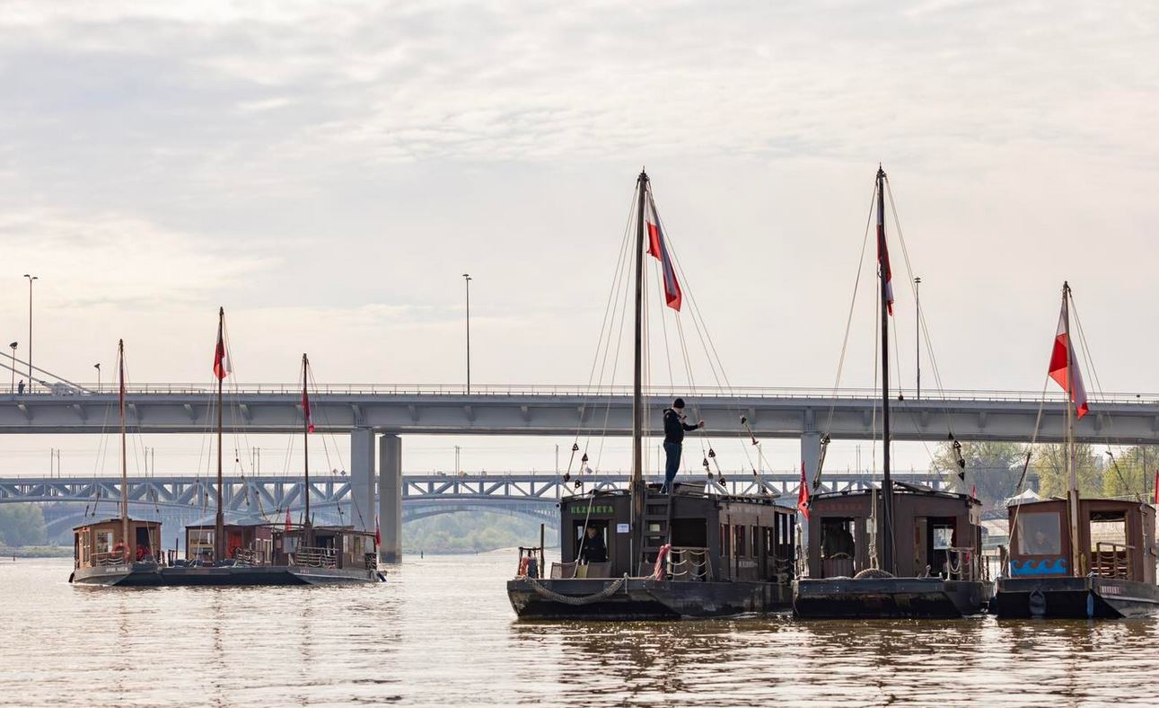 Drewniane łodzie na Wiśle, biało-czerwone flagi