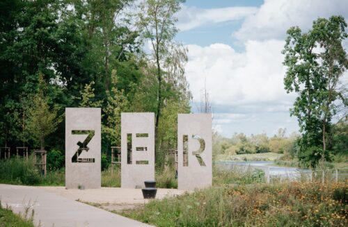 Park Żerański, kamienne płyty z napisem ŻER na tle alejki i zieleni