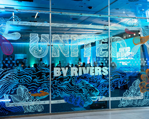 Napis United by rivers na szybie, narysowane fale